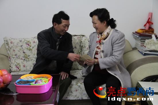 圖為州教育局黨組成員、紀(jì)檢組長龍利平（左）為邵天英送上慰問金。.jpg