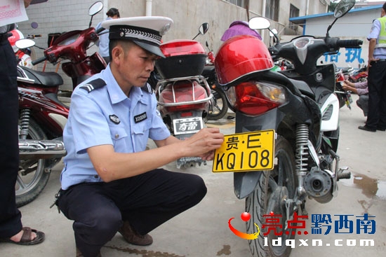 圖為望謨縣交警隊民警正在為群眾安裝摩托車牌照 (1).jpg